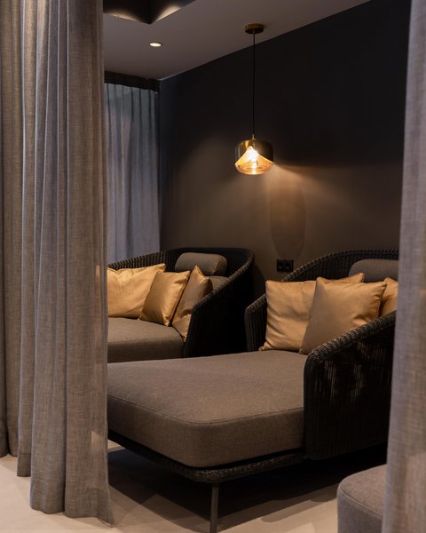 Bilder aus der Sportalm Gemütliche Sitzecke mit grauer Polsterung, goldenen Kissen und hängender Lampe