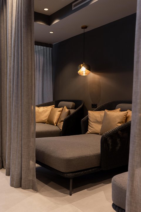 Pictures from Sportalm Cozy seating area with gray cushions, gold pillows, and hanging light