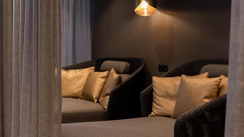 Pictures from Sportalm Cozy seating area with gray cushions, gold pillows, and hanging light