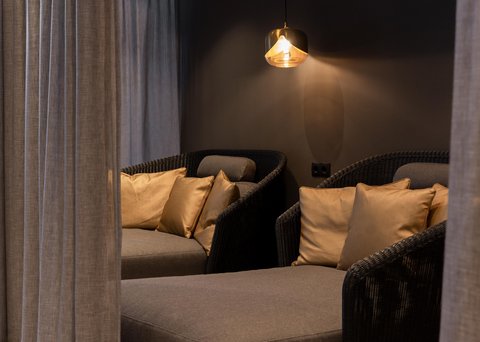 Pictures from Sportalm Cozy seating area with gray cushions, gold pillows, and hanging light