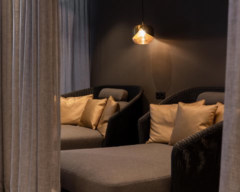 Pictures from Sportalm Cozy seating area with gray cushions, gold pillows, and hanging light