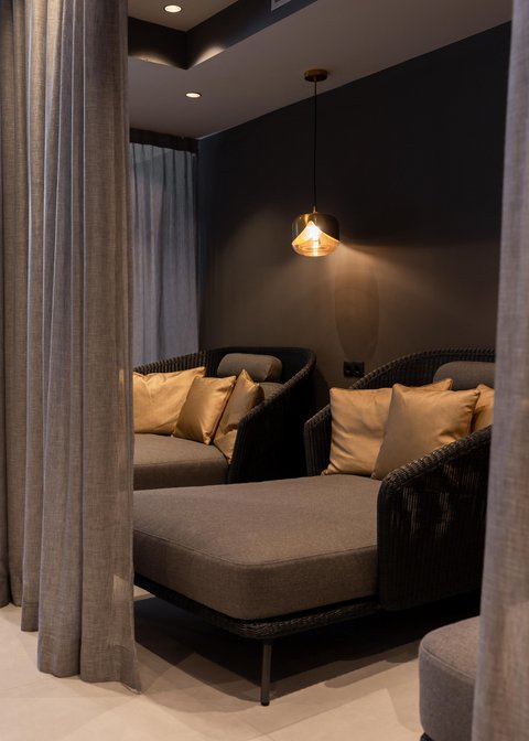 Bilder aus der Sportalm Gemütliche Sitzecke mit grauer Polsterung, goldenen Kissen und hängender Lampe