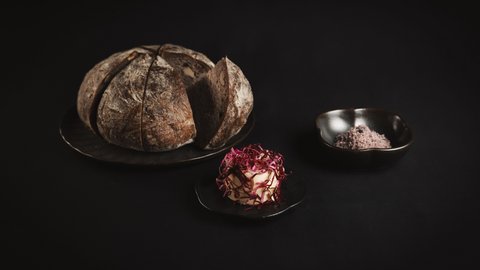 Pictures from Sportalm Round bread on plate with butter and salt against dark background