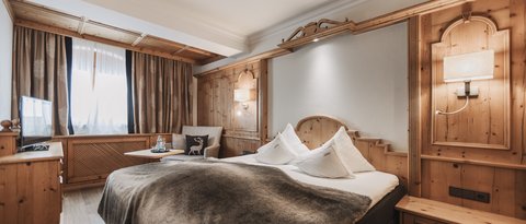 Bilder aus der Sportalm Gemütliches Hotelzimmer mit Holzverkleidung und großem Bett