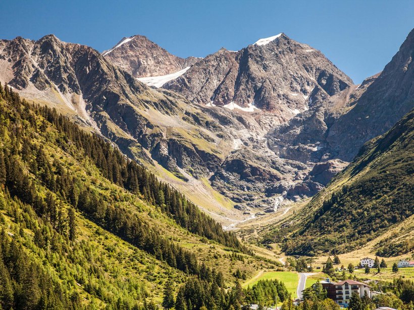 Live from St. Leonhard im Pitztal Mountain landscape with forested slopes and snow-capped peaks under blue sky