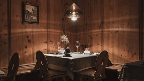 Bilder aus der Sportalm Gemütlicher Tisch mit Kerze und Gläsern in rustikalem Holzraum