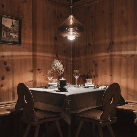 Bilder aus der Sportalm Gemütlicher Tisch mit Kerze und Gläsern in rustikalem Holzraum