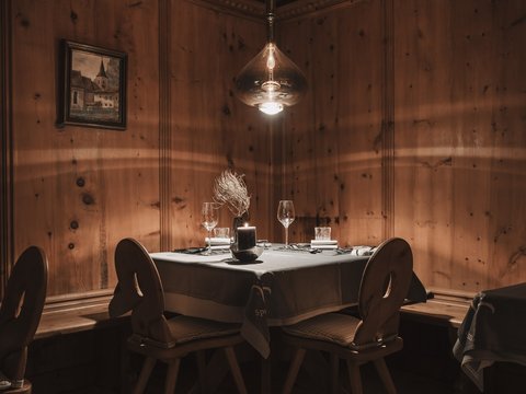 Bilder aus der Sportalm Gemütlicher Tisch mit Kerze und Gläsern in rustikalem Holzraum