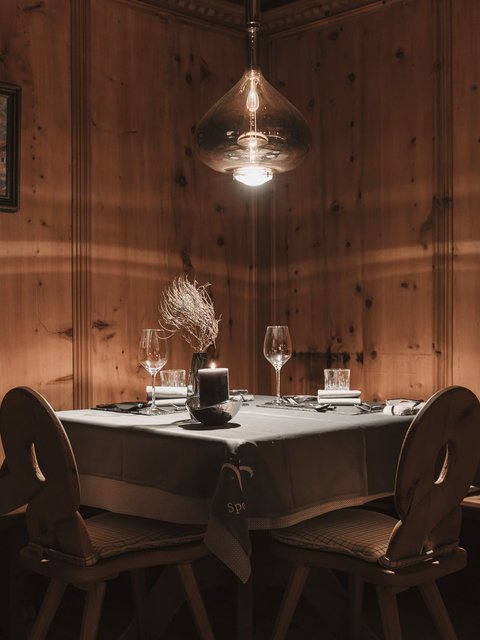 Bilder aus der Sportalm Gemütlicher Tisch mit Kerze und Gläsern in rustikalem Holzraum