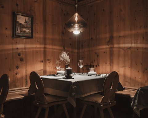 Bilder aus der Sportalm Gemütlicher Tisch mit Kerze und Gläsern in rustikalem Holzraum