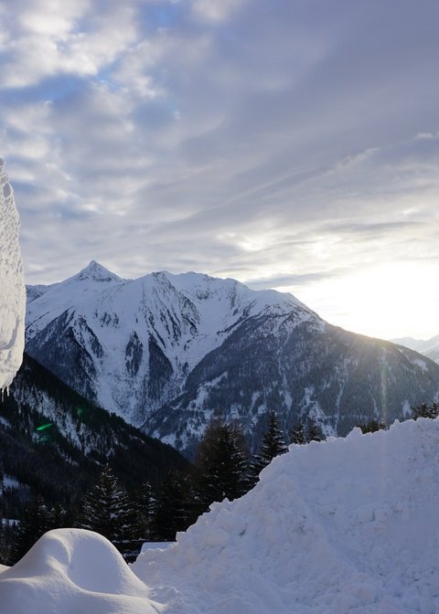 Pictures from Sportalm Snow-covered cabin and mountains at sunset