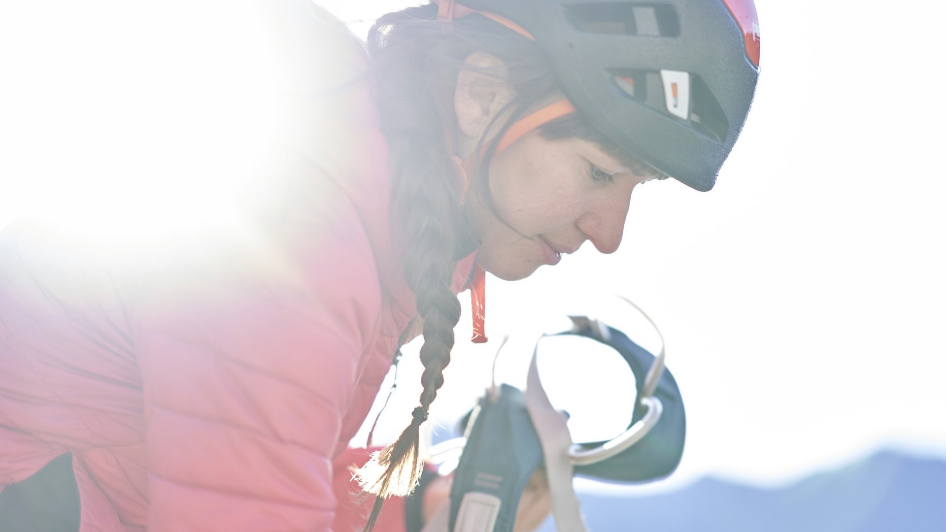 Climbing in Pitztal: adrenaline and thrill Woman wearing bike helmet holding bicycle bottle holder in sunlight