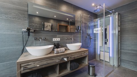 Pictures from Sportalm Modern bathroom with double sink, large mirror, and glass shower enclosure
