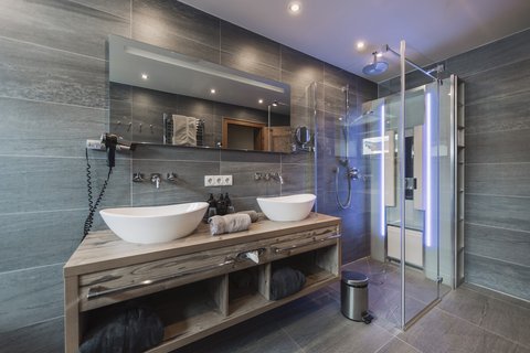 Pictures from Sportalm Modern bathroom with double sink, large mirror, and glass shower enclosure