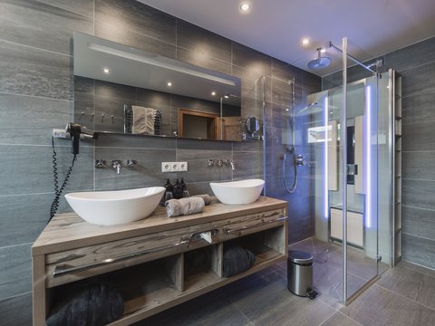Pictures from Sportalm Modern bathroom with double sink, large mirror, and glass shower enclosure