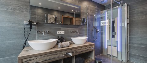 Pictures from Sportalm Modern bathroom with double sink, large mirror, and glass shower enclosure