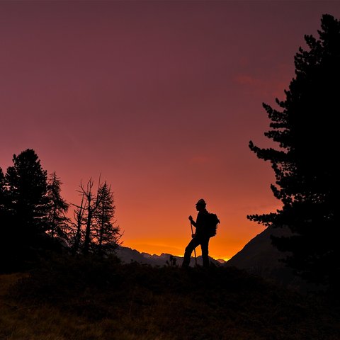 Bilder aus der Sportalm Silhouette eines Wanderers bei Sonnenuntergang in den Bergen