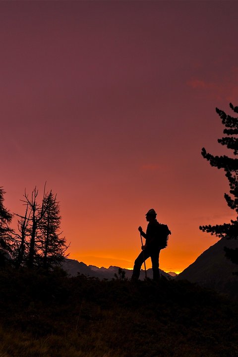 Bilder aus der Sportalm Silhouette eines Wanderers bei Sonnenuntergang in den Bergen