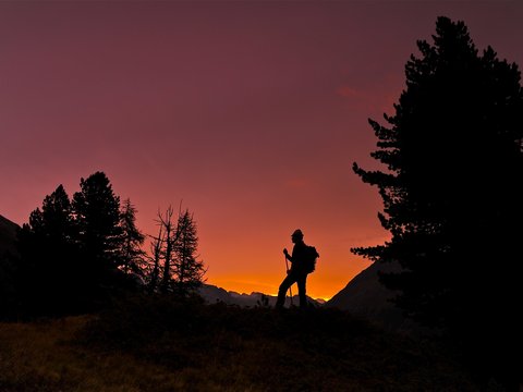 Bilder aus der Sportalm Silhouette eines Wanderers bei Sonnenuntergang in den Bergen