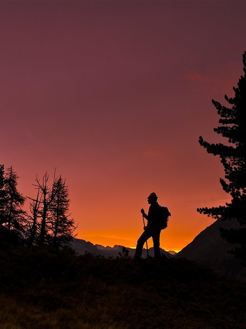 Bilder aus der Sportalm Silhouette eines Wanderers bei Sonnenuntergang in den Bergen