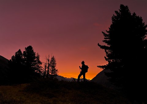 Bilder aus der Sportalm Silhouette eines Wanderers bei Sonnenuntergang in den Bergen