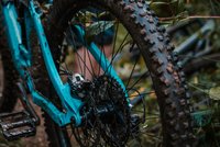 Nahaufnahme eines verschmutzten blauen Mountainbike-Hinterrads mit grobem Reifenprofil