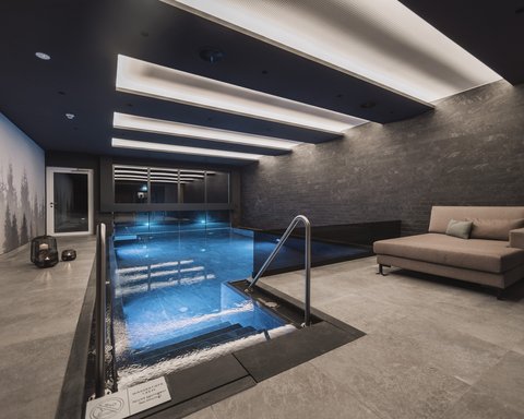 Bilder aus der Sportalm Modernes Hallenbad mit Sitzbereich und indirekter Deckenbeleuchtung