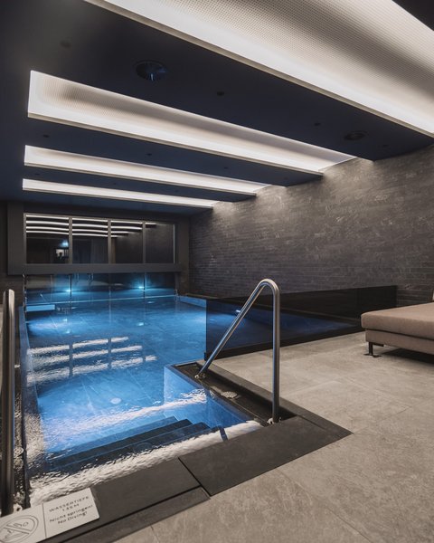 Bilder aus der Sportalm Modernes Hallenbad mit Sitzbereich und indirekter Deckenbeleuchtung