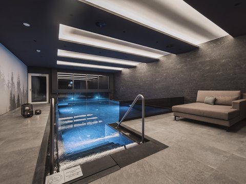 Bilder aus der Sportalm Modernes Hallenbad mit Sitzbereich und indirekter Deckenbeleuchtung