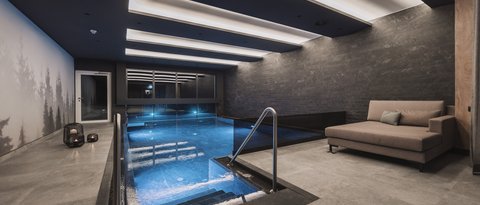 Bilder aus der Sportalm Modernes Hallenbad mit Sitzbereich und indirekter Deckenbeleuchtung