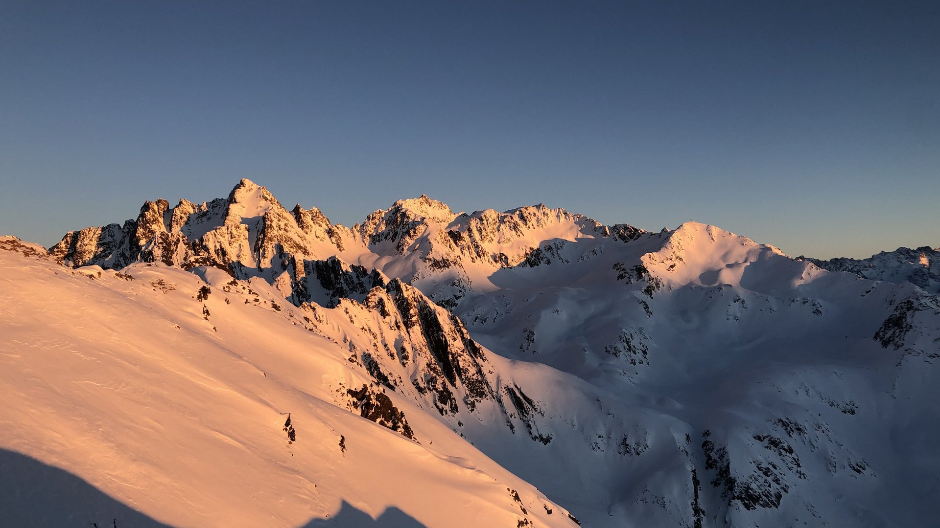 Live from St. Leonhard im Pitztal Snow-covered mountains glowing in sunset light under clear blue sky