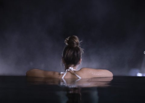 Bilder aus der Sportalm Frau entspannt sich nachts in einem Pool mit verschwommenem Hintergrund