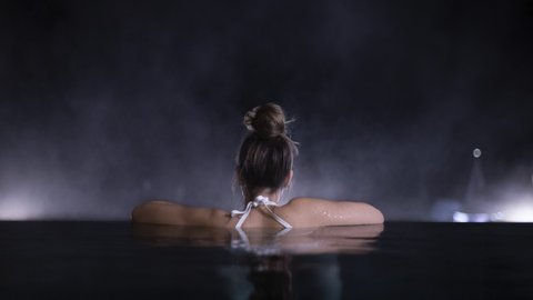 Pictures from Sportalm Woman relaxing in pool at night with blurred background