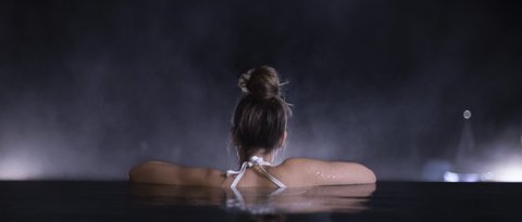 Bilder aus der Sportalm Frau entspannt sich nachts in einem Pool mit verschwommenem Hintergrund