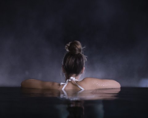 Bilder aus der Sportalm Frau entspannt sich nachts in einem Pool mit verschwommenem Hintergrund