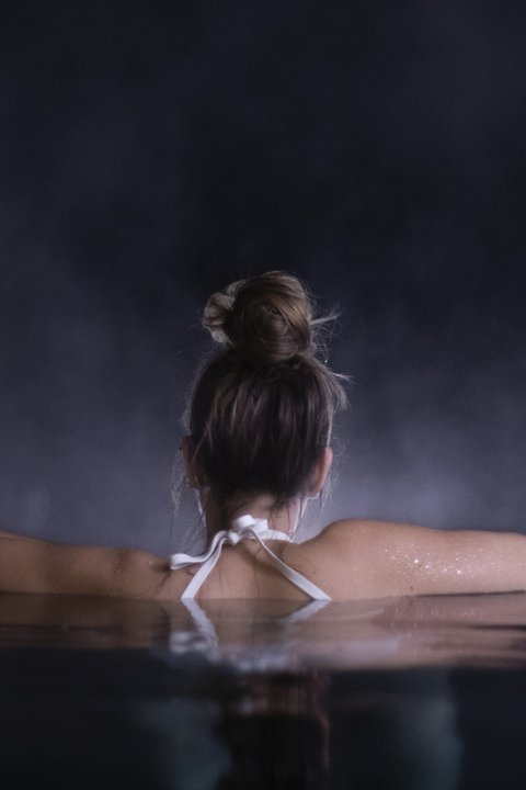 Bilder aus der Sportalm Frau entspannt sich nachts in einem Pool mit verschwommenem Hintergrund