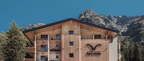 Bilder aus der Sportalm Alpenresort Sportalm mit Bergen im Hintergrund und geparkten Autos