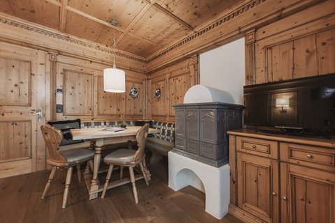 Pictures from Sportalm Cozy wooden room with corner bench, stove, and television
