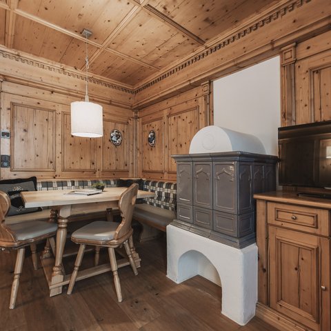 Pictures from Sportalm Cozy wooden room with corner bench, stove, and television