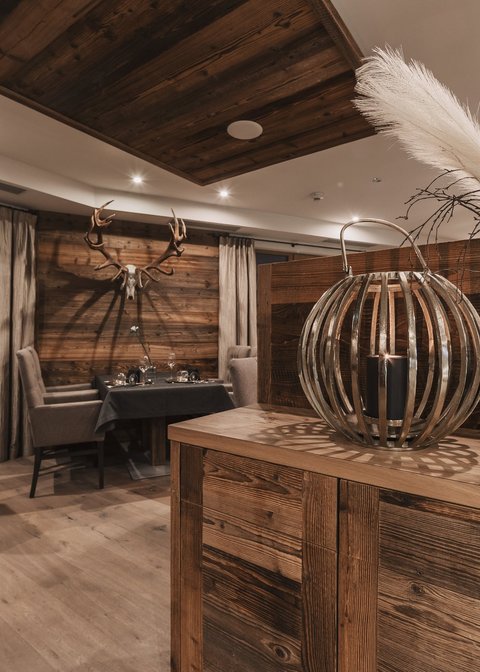 Bilder aus der Sportalm Rustikales Restaurant mit Holzmöbeln und Hirschgeweih an der Wand
