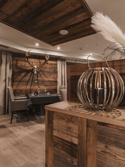 Bilder aus der Sportalm Rustikales Restaurant mit Holzmöbeln und Hirschgeweih an der Wand