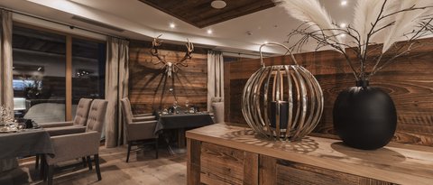 Bilder aus der Sportalm Rustikales Restaurant mit Holzmöbeln und Hirschgeweih an der Wand