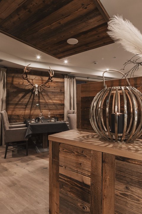 Bilder aus der Sportalm Rustikales Restaurant mit Holzmöbeln und Hirschgeweih an der Wand
