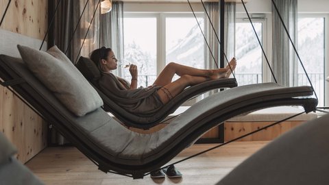 Bilder aus der Sportalm Frau entspannt auf hängender Liege im Wellnessbereich mit Bergblick