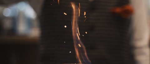 Pictures from Sportalm Bartender sprinkles spice on flaming drink in glass