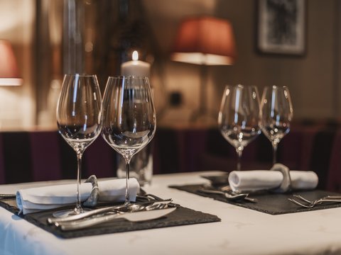 Unser Restaurant im Pitztal Eleganter gedeckter Tisch mit Weingläsern und Kerze in gedämpftem Licht