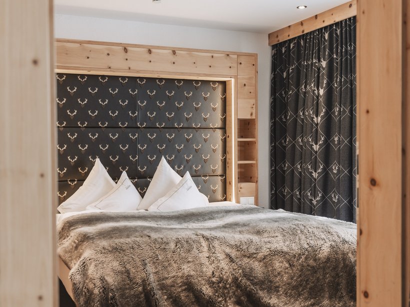 Nicht irgendein Pitztal-Resort: Alpine Resort Sportalm! Gemütliches Schlafzimmer mit Hirschmuster-Kopfteil und Vorhängen
