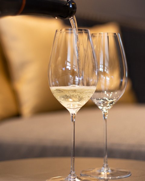 Pictures from Sportalm Wine being poured into wine glass with sofa in background
