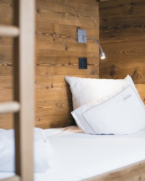 Pictures from Sportalm Single bed with white pillows and wooden wall in the background