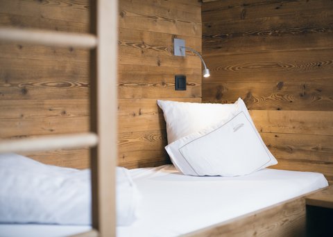 Pictures from Sportalm Single bed with white pillows and wooden wall in the background